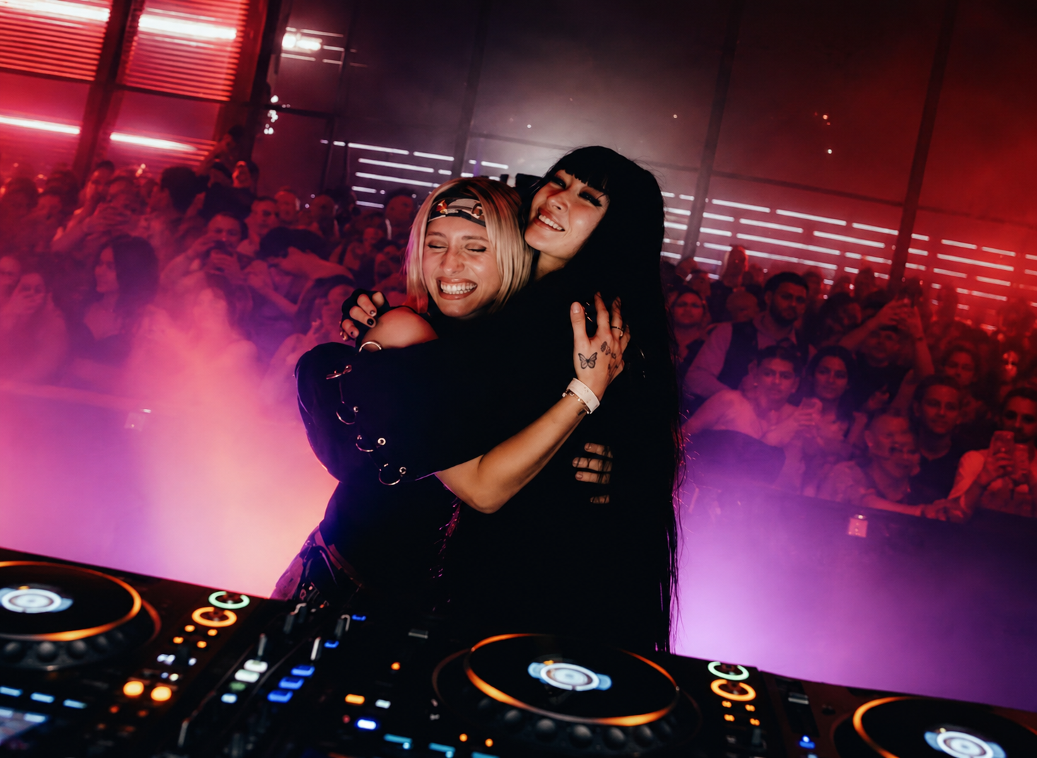 Joyful Hug at the Neon DJ Booth
